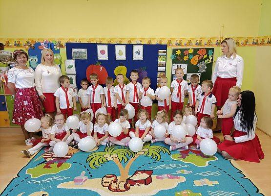 Zdjęcie grupowe przedszkolaków z paniami nauczycielkjami. Wszyscy w strojach biało-czerwonych