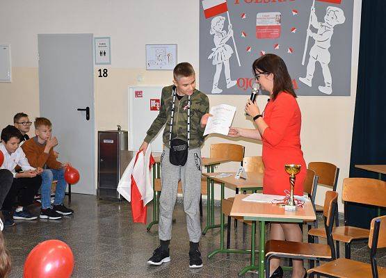 Nauczycielka wręcza uczniowi dyplom