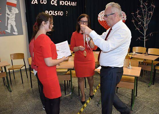 Dyrektor wręcza uczennicy medal