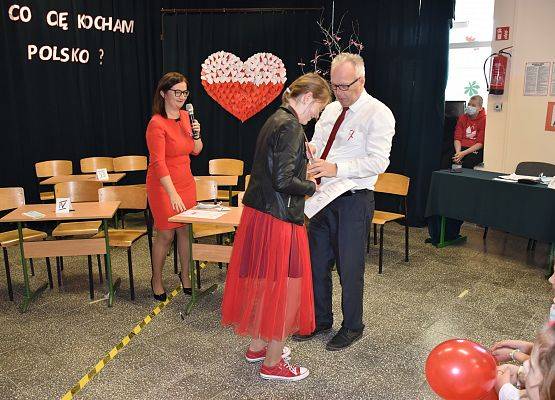 Dyrektor wręcza uczennicy medal