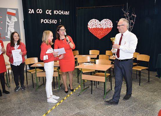 Dyrektor wręcza uczennicy puchar