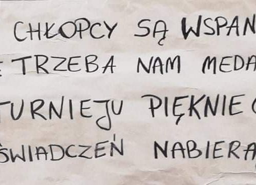 Plakat wykonany przez kibiców o treści: nasi chłopcy są wspaniali i nie trzeba nam medali, na turnieju pięknie grają i doświadczeń nabierają