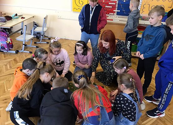 Dzieci z nauczycielką wykonują makietę małej ojczyzny