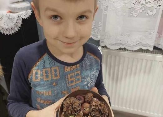 Uczeń pokazuje jesienne kasztany