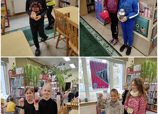 Uczniowie stoją w bibliotece i oglądają rekwizyty z bajek