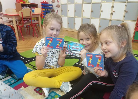 Trzy dziewczynki pokazują przygotowane zawieszki dla kierowców.