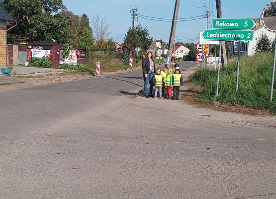 Dzieci wraz z nauczycielką na spacerze w poszukiwaniu znaków drogowych