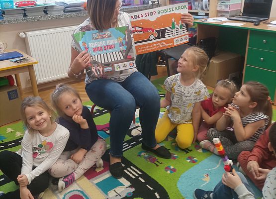 Nauczycielka pokazuje dzieciom plakaty projektowe