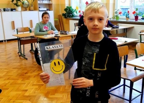 Uczeń prezentuje kartkę z okazji Dnia Życzliwości i Pozdrowień