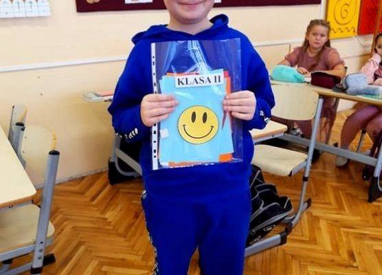 Uczeń prezentuje kartkę z okazji Dnia Życzliwości i Pozdrowień