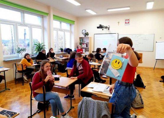 Uczennica prezentuje kartkę, którą otrzymała z okazji Dnia Życzliwości i Pozdrowień