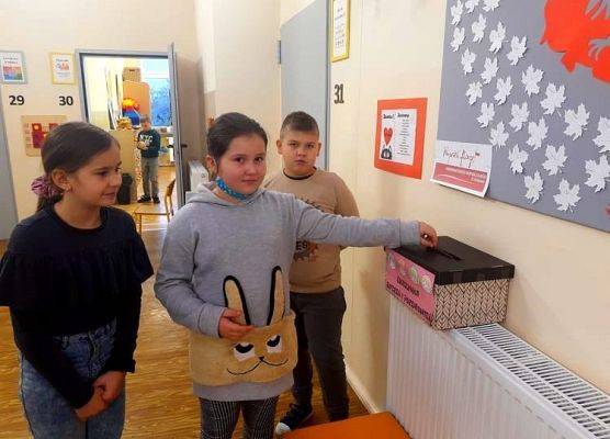 Uczniowie przy skrzynce do wrzucania kartek