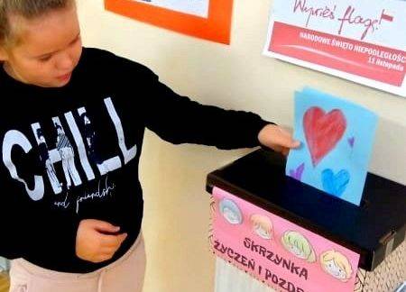 Uczennica wrzuca do skrzynki kartkę