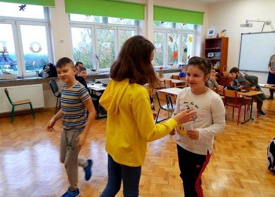 Wolontariuszka przekazuje kartki z życzeniami gospodarzowi klasy.