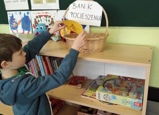 Uczennica siedząc przy stoliku opowiada o emocjach