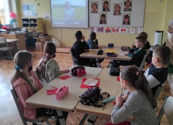 Uczniowie siedzą przy stolikach i pracując w grupach