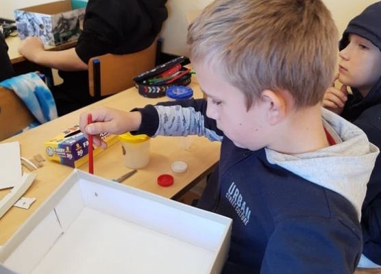 Uczeń maluje pudełko