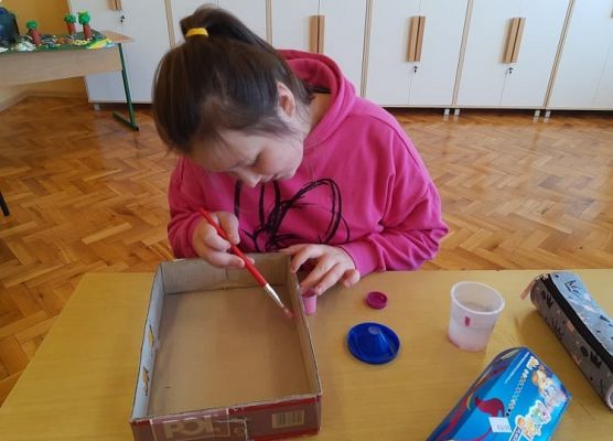 Uczennica maluje karton
