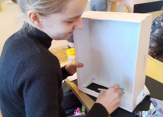 Uczennica mierzy karton