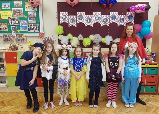 Przebrane uczennice stoją z nauczycielką