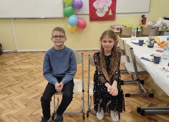 dzieci siedzą na krzesłach