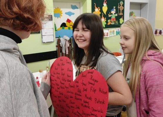 Dziewczynki podczas wróżby z papierowym sercem