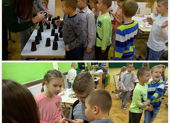 Uczniowie stoją przy stole z kubkami