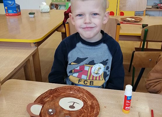 Chłopiec maluje farbą papierowy talerz