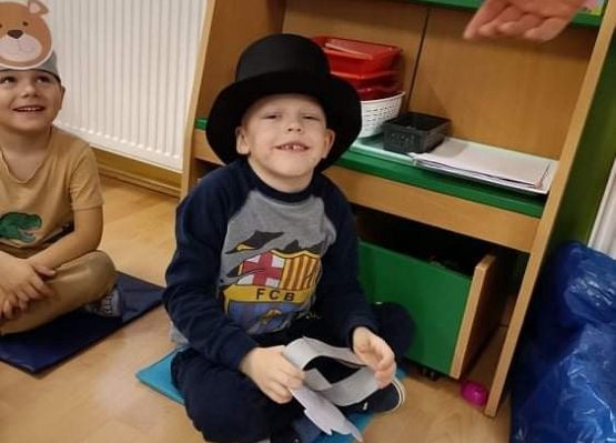 Chłopiec w kapeluszu siedzi na podłodze