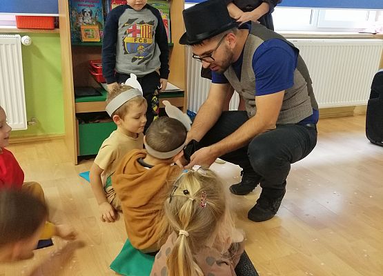 Animator w przebraniu czarodzieja pokazuje sztuczkę