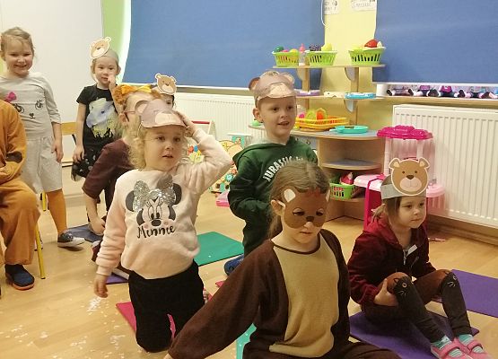 Dzieci siedzą i oglądają występ czarodzieja