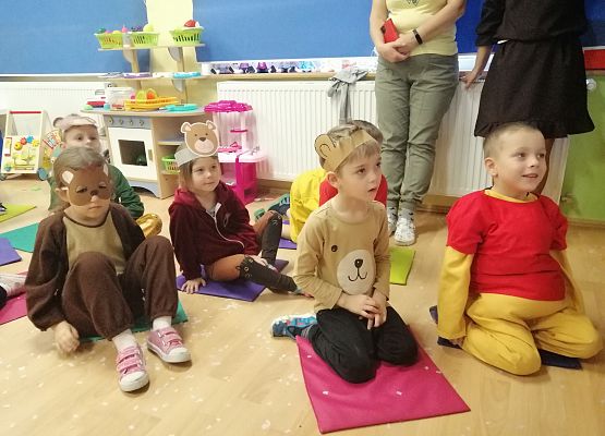 Dzieci siedzą i oglądają występ czarodzieja