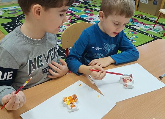 Chłopcy malują gipsowe misie