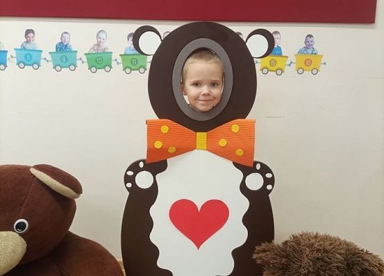 Dziecko pozuje do zdjęcia w makiecie misia