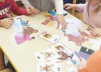 Dzieci przeglądają ilustracje z misiami