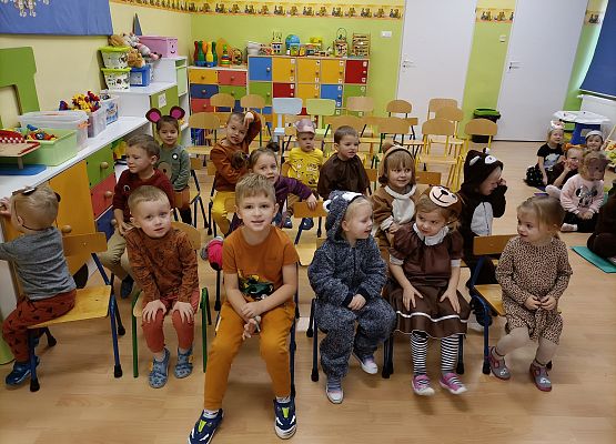 Przedszkolaki siedzą na krzesłach czekając na pokaz magii