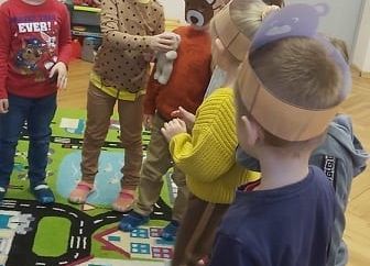 Dzieci podają sobie misia