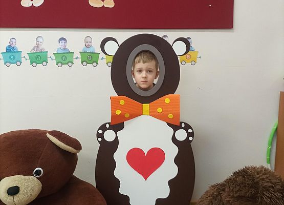 Dziecko pozuje do zdjęcia w makiecie misia