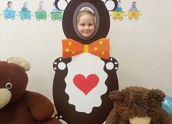 Dziecko pozuje do zdjęcia w makiecie misia