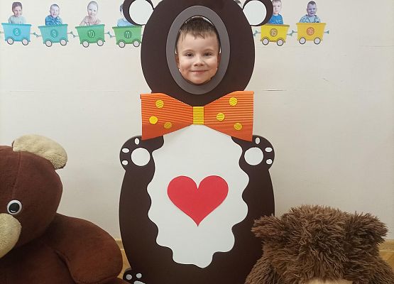 Dziecko pozuje do zdjęcia w makiecie misia