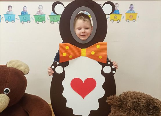 Dziecko pozuje do zdjęcia w makiecie misia