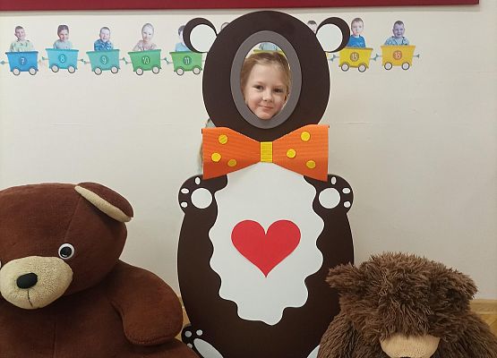 Dziecko pozuje do zdjęcia w makiecie misia