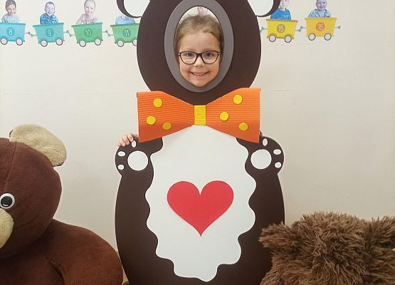 Dziecko pozuje do zdjęcia w makiecie misia