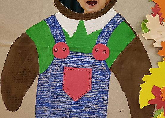 Dziecko pozuje do zdjęcia w makiecie misia