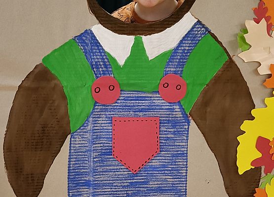 Dziecko pozuje do zdjęcia w makiecie misia