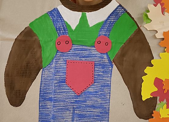 Dziecko pozuje do zdjęcia w makiecie misia