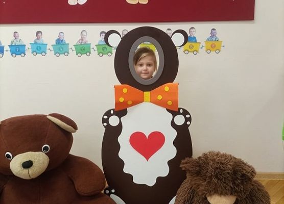 Dziecko pozuje do zdjęcia w makiecie misia