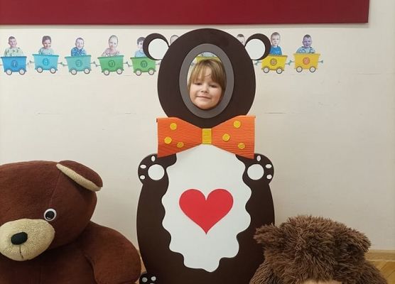 Dziecko pozuje do zdjęcia w makiecie misia