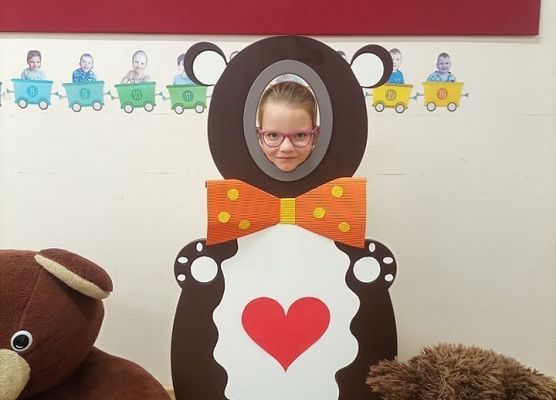 Dziecko pozuje do zdjęcia w makiecie misia