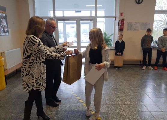 Pan Dyrektor i Pani Wicedyrektor wręczają uczennicy nagrodę